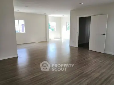 Spacious empty room with wooden flooring and natural light