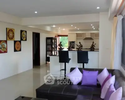 Spacious living room with modern decor and open kitchen layout