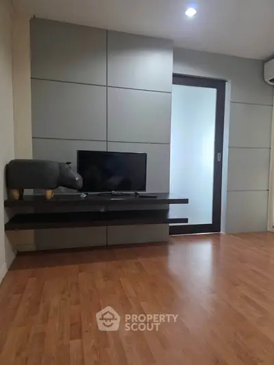 Modern living room with sleek TV stand and wooden flooring