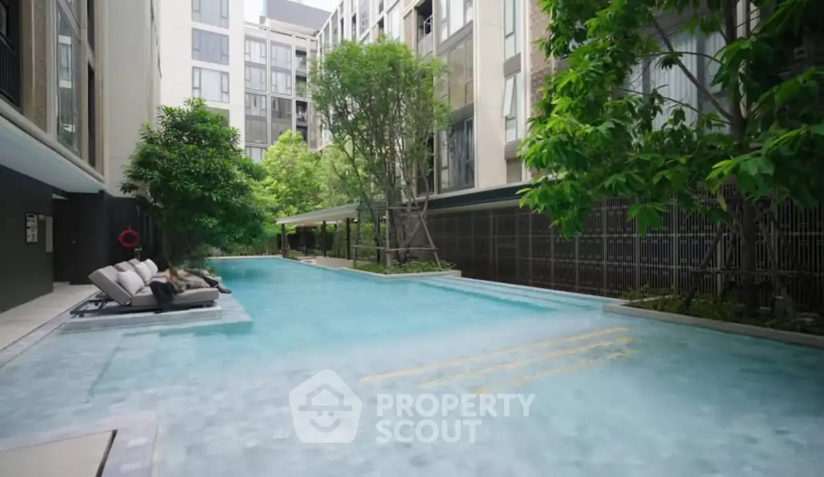 Luxurious apartment complex with serene pool and lush greenery