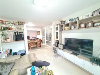 Spacious living room with modern decor and large TV, perfect for family gatherings.