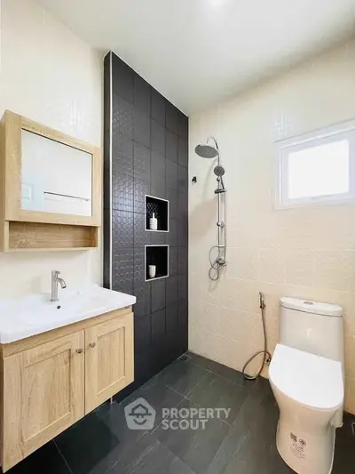 Modern bathroom with sleek black tiles and wooden vanity