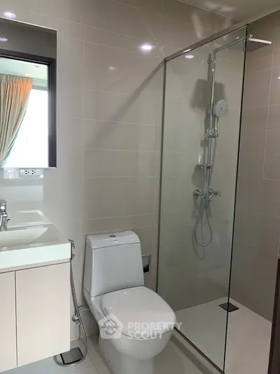 Modern bathroom with glass shower and sleek fixtures in contemporary apartment