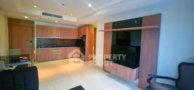 Modern open-plan living room with sleek kitchen and stylish wood cabinetry.