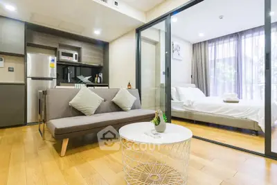 Modern open-plan living room with cozy sofa and stylish bedroom view.