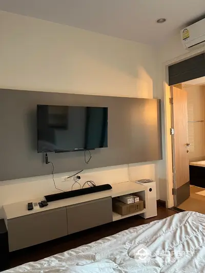 Modern bedroom with wall-mounted TV and air conditioning unit