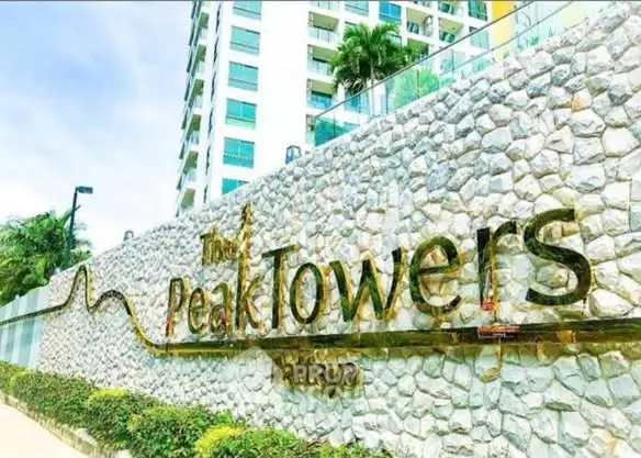 Luxurious Peak Towers Pattaya exterior with elegant stone facade and lush greenery.