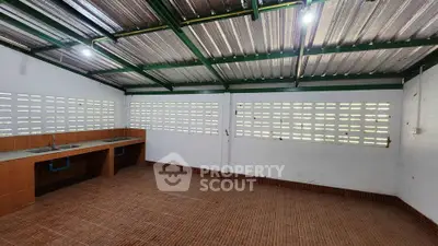 Spacious open-layout kitchen with tiled flooring and ample natural light, perfect for culinary enthusiasts.