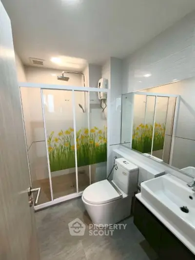 Modern bathroom with glass shower and sleek fixtures in a contemporary apartment.