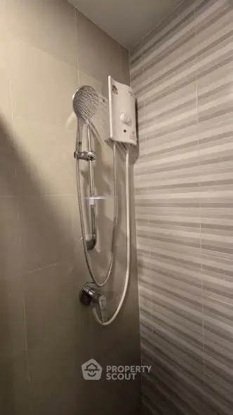 Modern bathroom shower with sleek tiles and water heater, perfect for a refreshing experience.