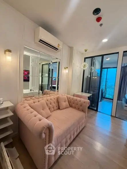 Chic living room with plush sofa and modern decor, featuring a balcony view.