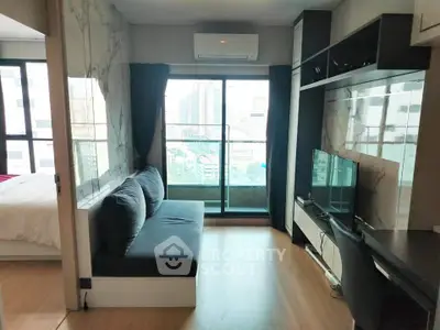 Modern living room with city view, featuring sleek furniture and large windows for natural light.