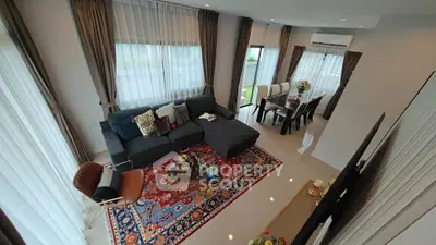 Spacious living room with elegant decor and large windows, featuring a cozy sectional sofa and dining area.