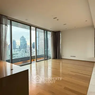 Spacious modern living room with stunning city view and floor-to-ceiling windows.