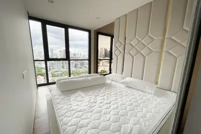 Luxurious bedroom with floor-to-ceiling windows offering stunning city views.