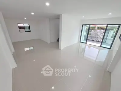 Spacious modern living room with glossy tiled floors and large sliding glass doors.