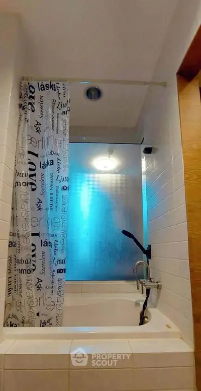 Cozy bathroom with bathtub and stylish shower curtain in modern apartment.