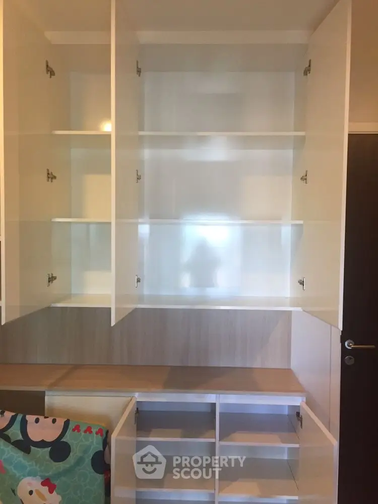 Spacious built-in storage cabinets with open shelving in modern interior design.
