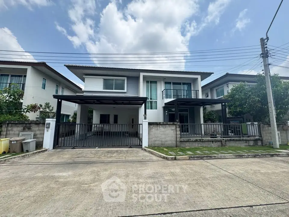 Modern two-story house with spacious driveway and lush greenery in a serene neighborhood.