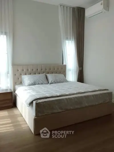 Elegant bedroom with plush bed and natural light, perfect for relaxation.