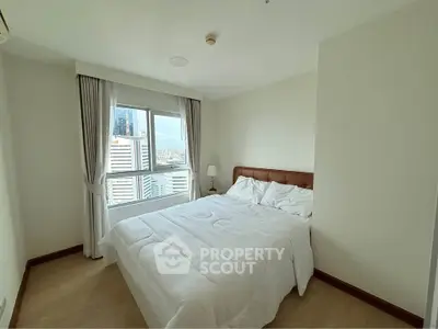 Bright and cozy bedroom with city view, featuring a comfortable bed and large window.
