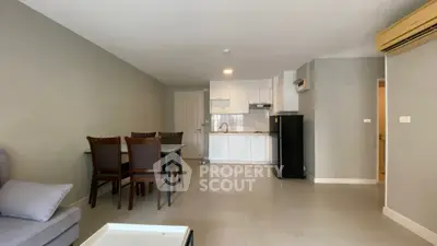 Modern open-plan living room with dining area and compact kitchen in neutral tones.