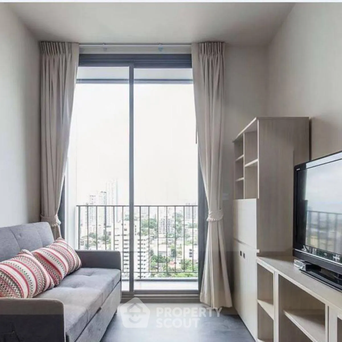 Modern living room with city view, featuring a cozy sofa and entertainment unit.