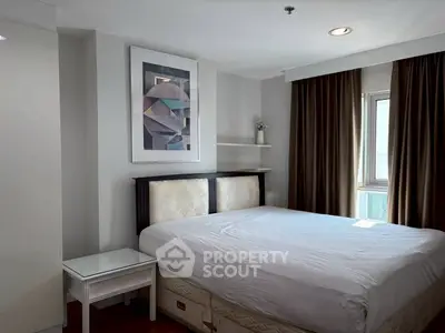 Spacious bedroom with modern decor and large window offering natural light.