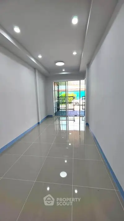 Spacious modern hallway with glossy tiled floors and recessed lighting