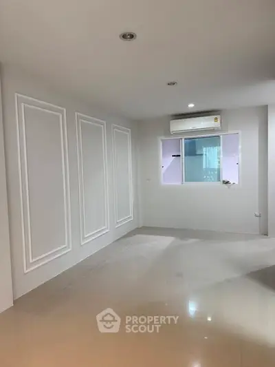 Spacious empty room with glossy tiled floor and air conditioning, perfect for customization.