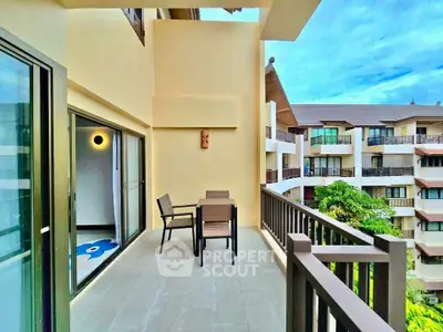 Spacious balcony with outdoor seating and scenic view of modern apartment complex.