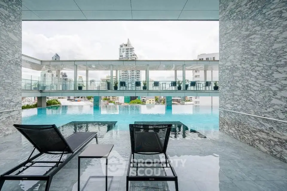 Luxurious rooftop pool with stunning city views and modern lounge chairs, perfect for relaxation.