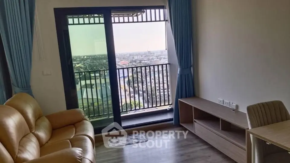 Modern living room with balcony offering stunning city view, featuring cozy leather sofa and stylish furniture.