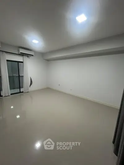 Spacious empty room with glossy tiled floor and large window, ideal for customization.