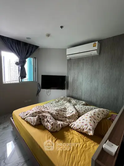 Cozy bedroom with modern decor and air conditioning, featuring a large window for natural light.