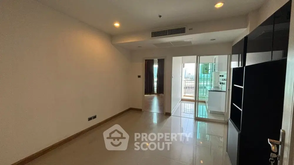 Spacious unfurnished living room with balcony access and city view
