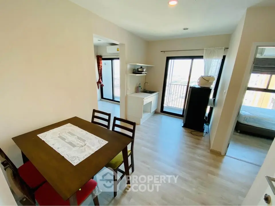 Modern open-layout apartment with dining area and balcony view.