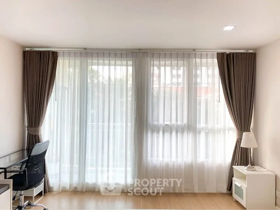 Bright study room with large windows and elegant curtains