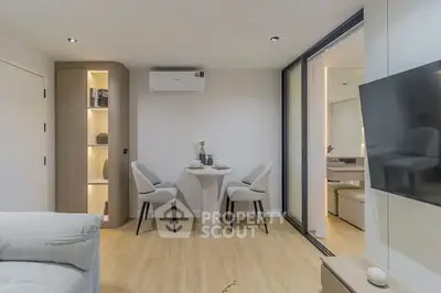Modern living room with sleek furniture and open layout, featuring a cozy dining area and stylish decor.