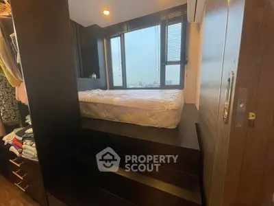 Modern bedroom with elevated bed and city view, featuring sleek design and ample storage space.