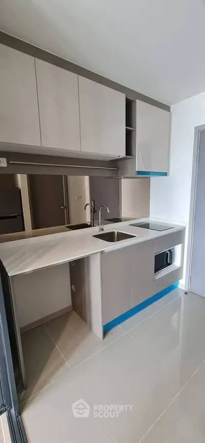 Modern kitchen with sleek cabinetry and built-in appliances in a contemporary apartment.