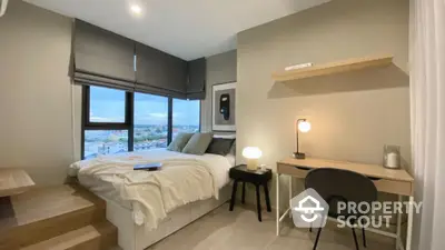 Modern bedroom with cozy decor and city view, featuring a stylish desk and comfortable bed.