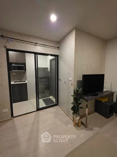 Modern living room with open kitchen and sleek decor in a stylish apartment.