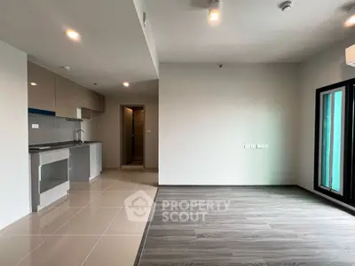 Modern open-plan living room with sleek kitchen and stylish flooring in a contemporary apartment.