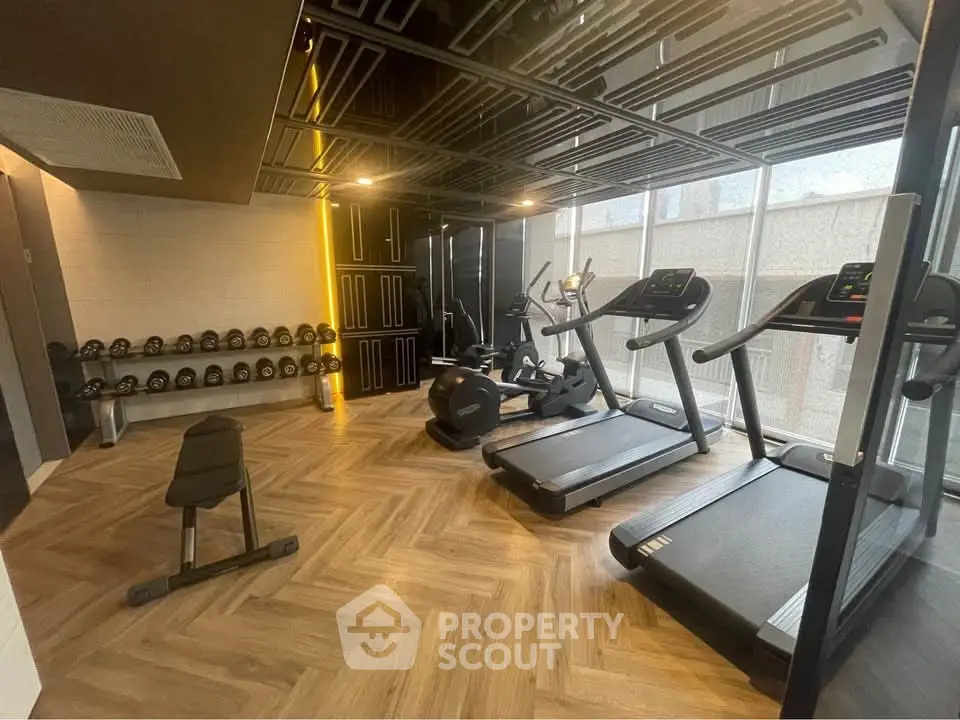 Modern gym with treadmills and weights in a stylish real estate property.