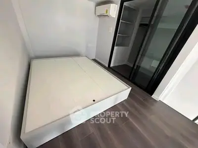 Modern minimalist bedroom with built-in closet and air conditioning unit.