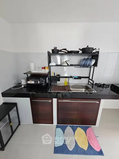 Modern kitchen with sleek cabinetry, gas stove, and stylish dish rack, perfect for culinary enthusiasts.