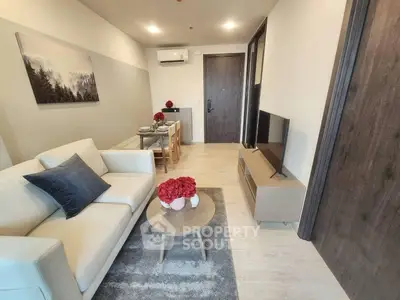 Modern living room with cozy sofa, flat-screen TV, and elegant decor in a stylish apartment.