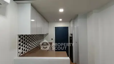 Modern kitchen with sleek cabinetry and geometric backsplash design