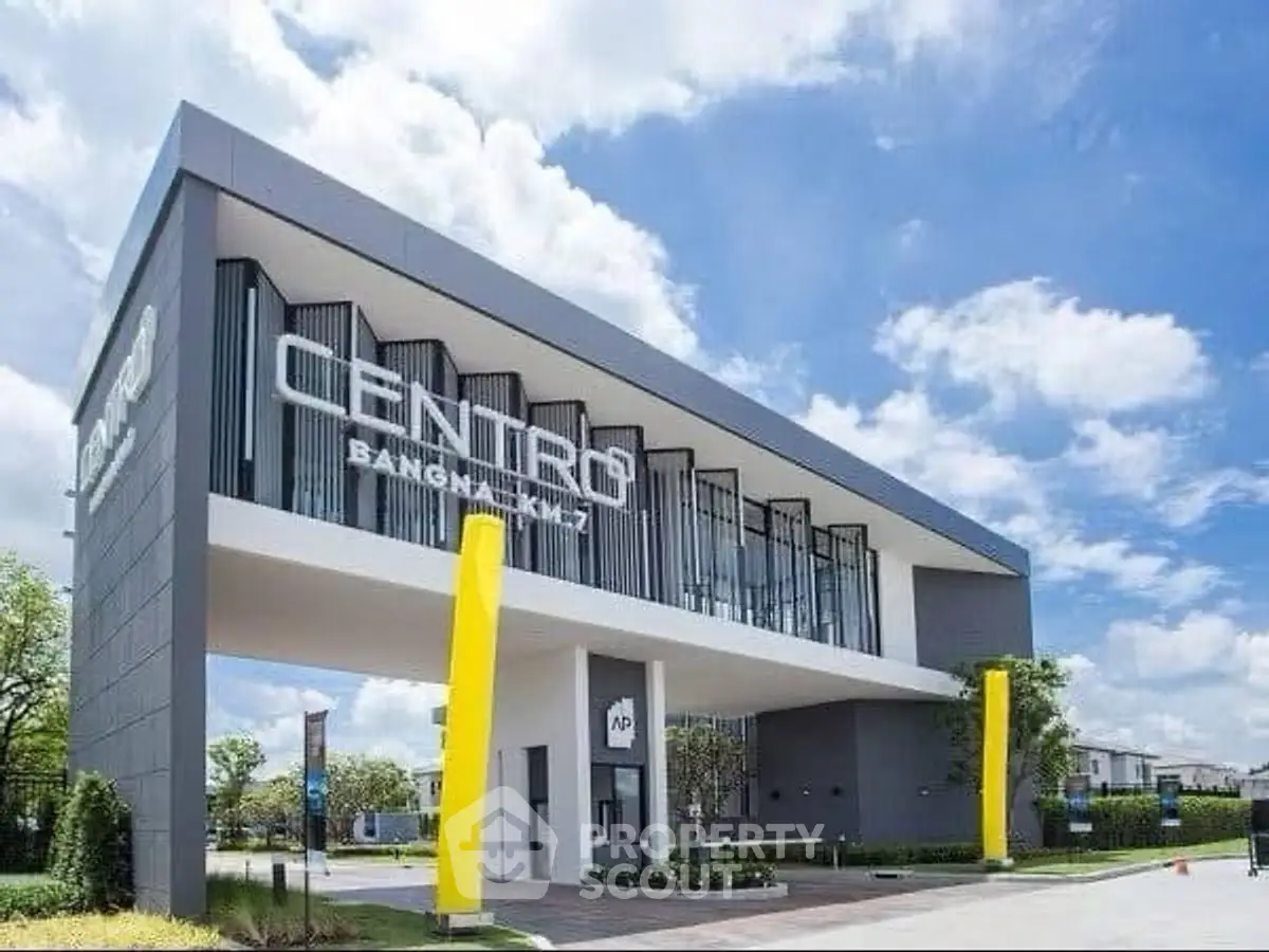 Modern architectural building with sleek design and vibrant yellow accents under a clear blue sky.